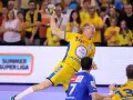 Piłkarz ręczny w żółtej koszulce z numerem 14 rzuca piłkę podczas eliminacji mistrzostw europy w piłce ręcznej grupa polska.