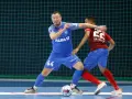 Jakub Grzybowski w akcji, walczy o piłkę z przeciwnikiem na boisku futsalowym.