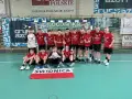 Drużyna piłki ręcznej z numerami na koszulkach, w tym Damian Borkowski, świętuje zwycięstwo.