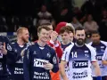 Emil Jakobsen z brodą i numerem 14 na koszulce, w otoczeniu drużyny piłkarzy ręcznych.