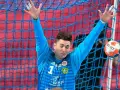 Mateusz Kaczmarczyk, bramkarz w akcji, z rękami uniesionymi do obrony, piłka zmierza w jego stronę.