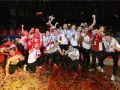 Damian Domagała i drużyna świętują zwycięstwo, unosząc puchar wśród konfetti.