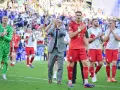 Piłkarze reprezentacji Polski po losowaniu mistrzostw Europy, w geście szacunku dla kibiców, klaszczą na murawie.