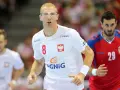 Kamil Bielecki w okularach ochronnych, z numerem 8 na koszulce, biegnie podczas meczu. Obok zawodnik z numerem 29.