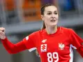 Kinga Achruk, zawodniczka z numerem 89 na czerwonej koszulce, unosi zaciśniętą pięść w geście triumfu.