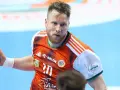 Piłkarz ręczny w pomarańczowej koszulce z numerem 10, gotowy do rzutu. To emocje z superligi kobiet!