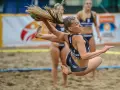 Zawodniczka w skoku po piłkę podczas meczu piłki ręcznej plażowej.