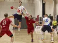 Konrad Małek w skoku po piłkę do ręcznej, broniony przez przeciwnika.