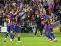 Piłkarze FC Barcelona, w tym Lewandowski, świętują zwycięstwo. Duma i radość na twarzach, to jest **vive Barcelona**!
