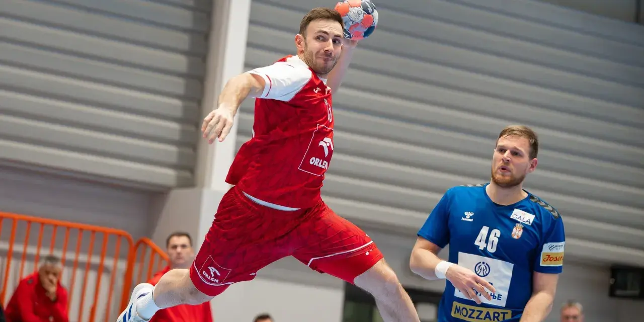 Piłkarz ręczny w skoku do rzutu, w czerwonej koszulce z logo ORLEN. Obok niego stoi zawodnik w niebieskiej koszulce z numerem 46. To reprezentacja Serbii w piłce ręcznej mężczyzn.
