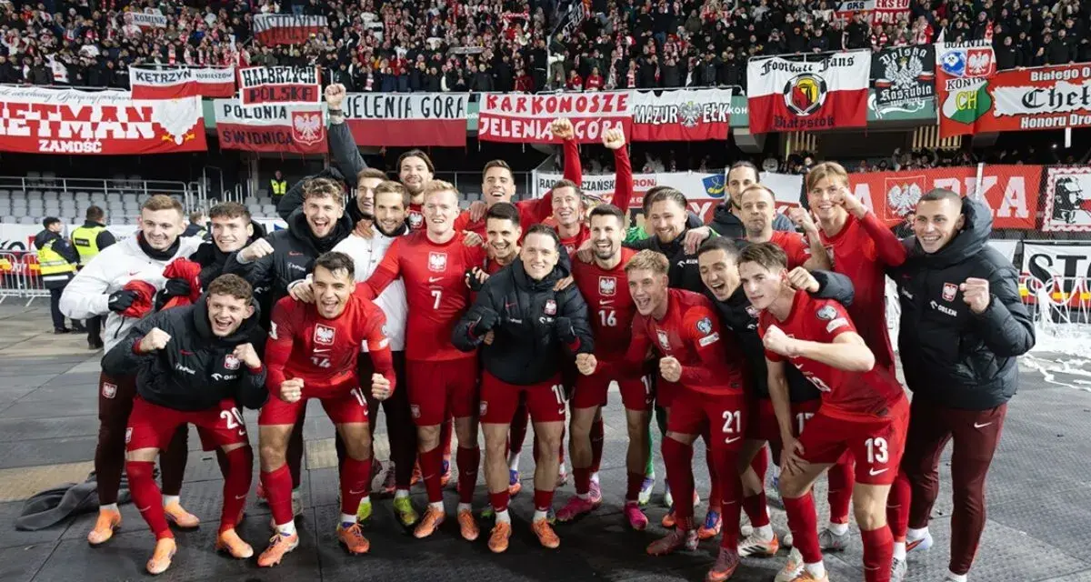 Radosna me grupa polska w czerwonych strojach świętuje z kibicami.