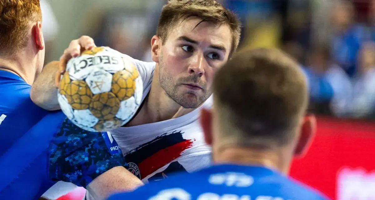 Piłkarz ręczny Luc Steins z piłką w ręku, otoczony przez obrońców.