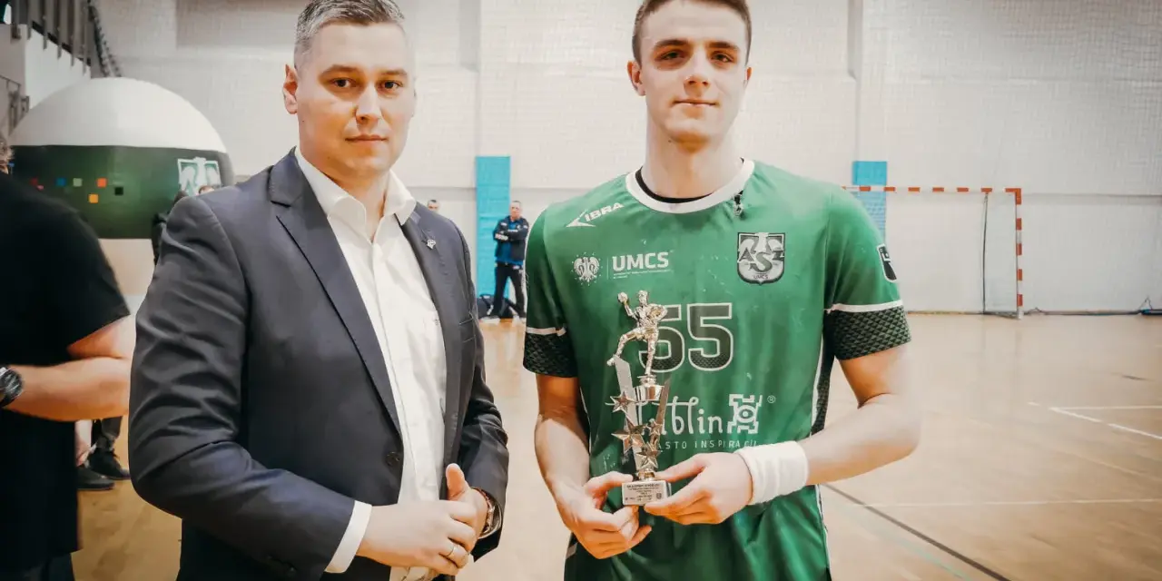 Andrzej Widomski z pucharem w ręku, obok młody sportowiec w zielonej koszulce.