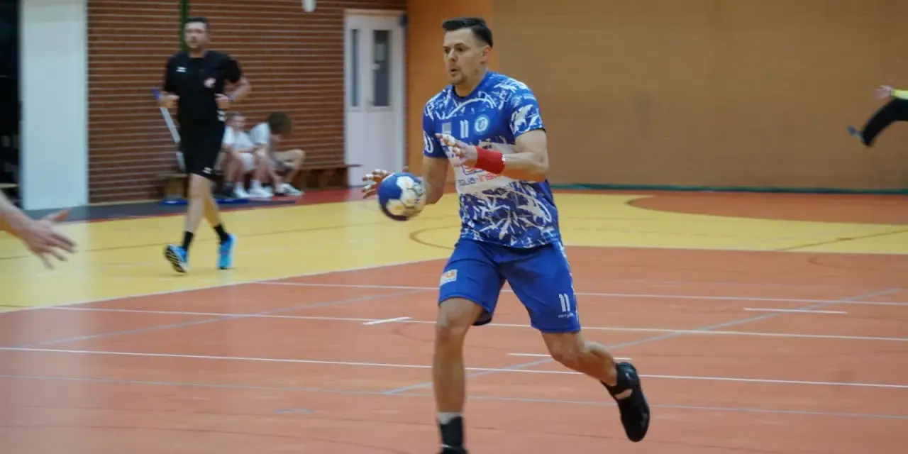 Kamil Krieger w akcji na boisku do piłki ręcznej, z piłką w dłoni, gotowy do rzutu.
