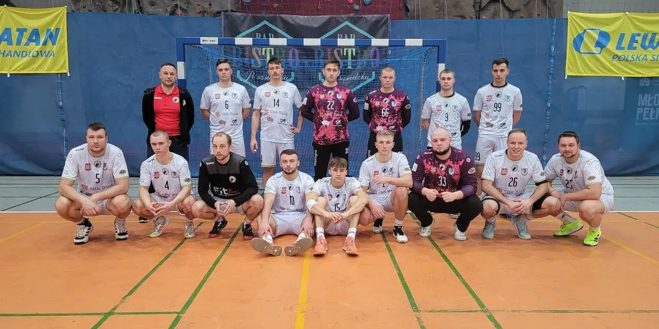 Drużyna piłkarzy ręcznych, w tym Wojciech Stec, pozuje do zdjęcia w hali sportowej.