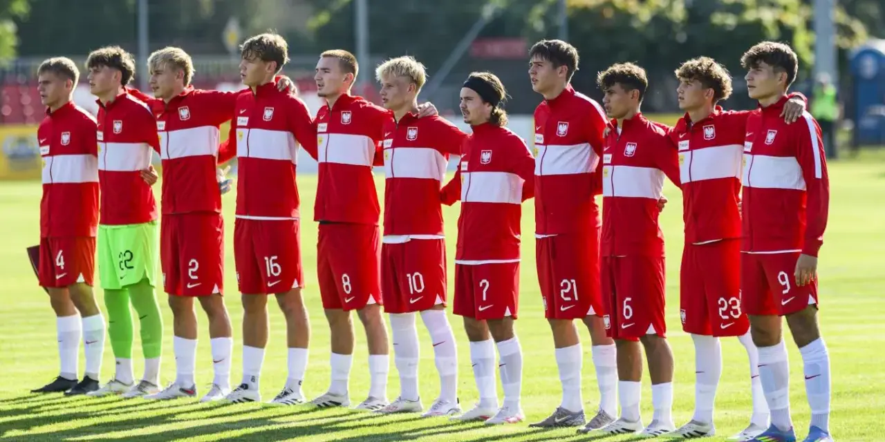 Drużyna Polski na Mistrzostwach Europy do lat 17. Piłkarze w czerwonych strojach z białymi pasami stoją w rzędzie, gotowi do meczu.