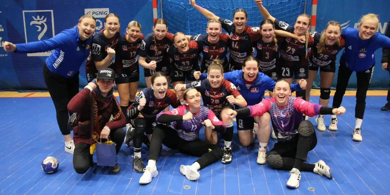 Drużyna piłki ręcznej KPR Bukowsko Dopiewo świętuje zwycięstwo. Radosne zawodniczki w strojach sportowych, z numerami na koszulkach, pozują do zdjęcia z trenerem.