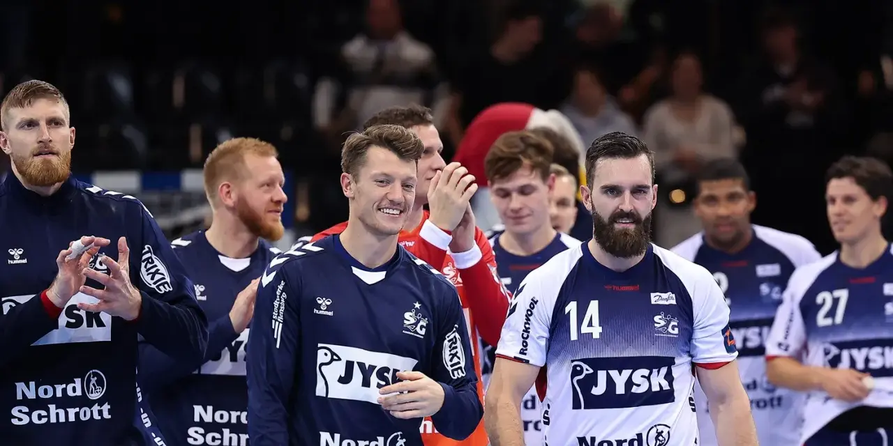 Emil Jakobsen z brodą i numerem 14 na koszulce, w otoczeniu drużyny piłkarzy ręcznych.