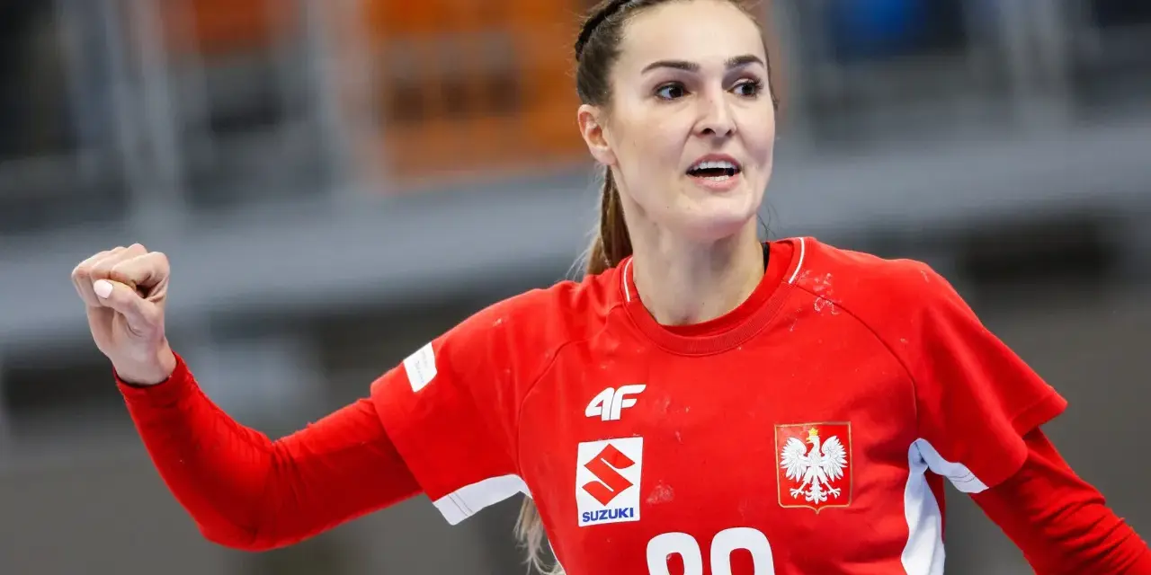 Kinga Achruk, zawodniczka z numerem 89 na czerwonej koszulce, unosi zaciśniętą pięść w geście triumfu.