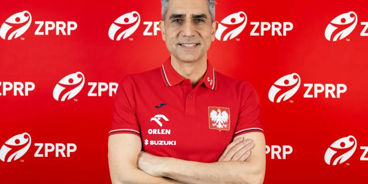 Trenerzy reprezentacji Polski w piłce ręcznej, w tym nowy selekcjoner, pozują na tle czerwonej ściany z logo ZPRP.