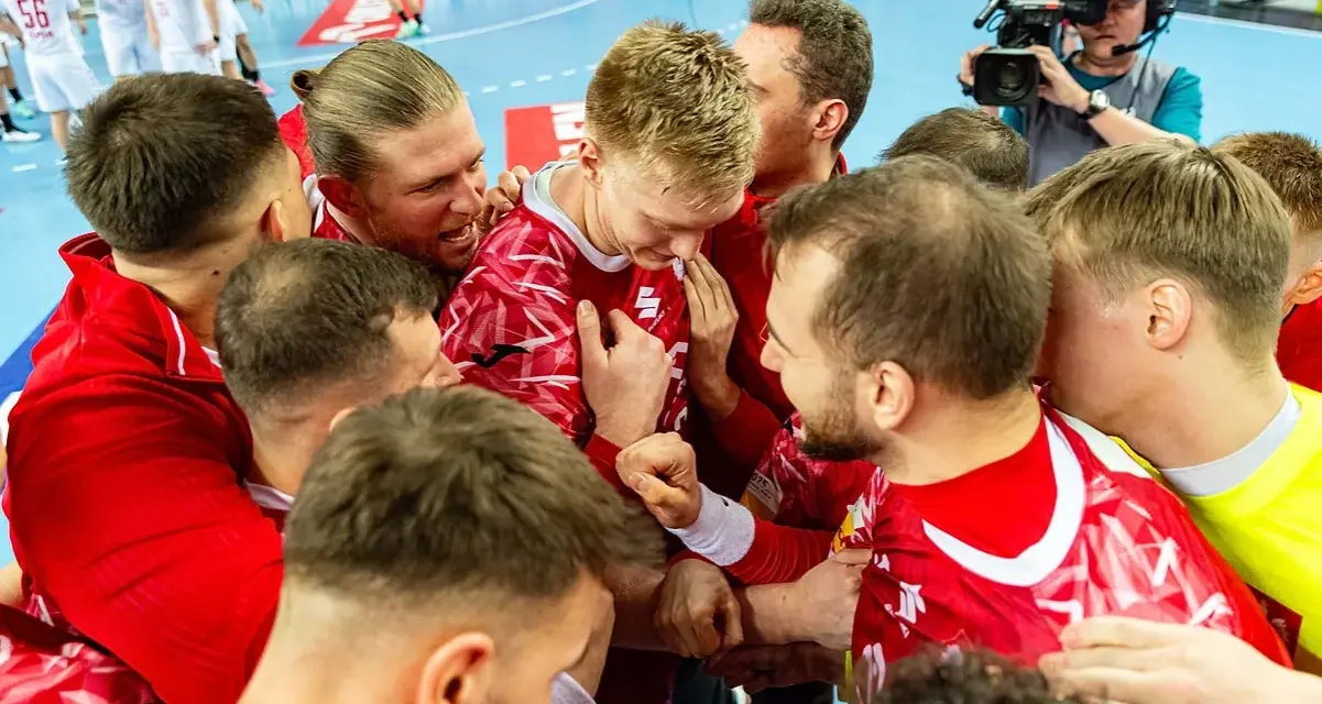 Piłkarze ręczni w czerwonych strojach świętują zwycięstwo. Emocje po meczu, a gdzieś w tle czeka mistrzostwa świata w piłce ręcznej terminarz.