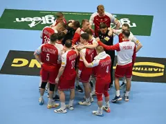 Drużyna piłkarzy ręcznych Polski w czerwonych strojach z białymi detalami, zjednoczona w kółku. To kluczowy moment przed meczem, być może decydującym o dalszych losach w mistrzostwach świata.