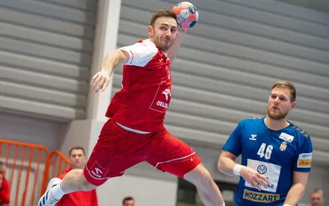 Piłkarz ręczny w skoku do rzutu, w czerwonej koszulce z logo ORLEN. Obok niego stoi zawodnik w niebieskiej koszulce z numerem 46. To reprezentacja Serbii w piłce ręcznej mężczyzn.