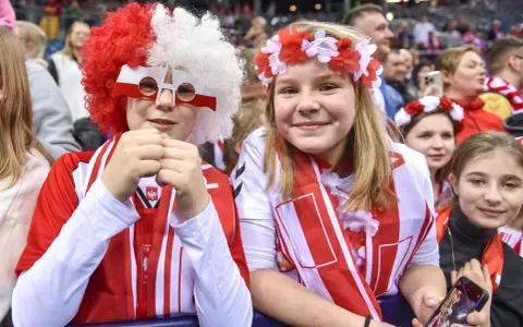 Dzieci kibicują w barwach narodowych podczas meczu pierwszej ligi piłki ręcznej.