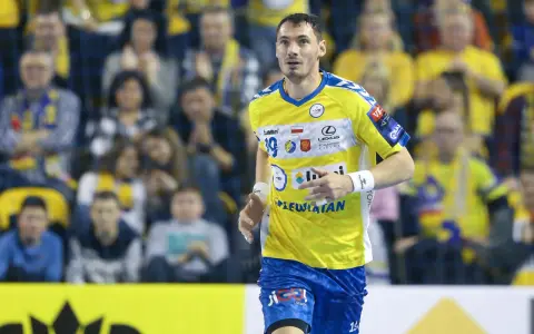 Piłkarz ręczny Kentin Mahé w żółtej koszulce z niebieskimi detalami, z numerem 19, biegnie na boisku.