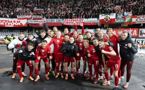 Radosna me grupa polska w czerwonych strojach świętuje z kibicami.