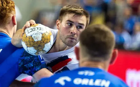 Piłkarz ręczny Luc Steins z piłką w ręku, otoczony przez obrońców.