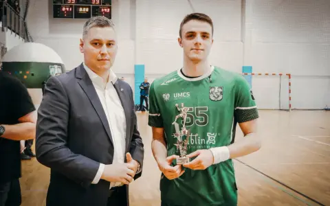 Andrzej Widomski z pucharem w ręku, obok młody sportowiec w zielonej koszulce.