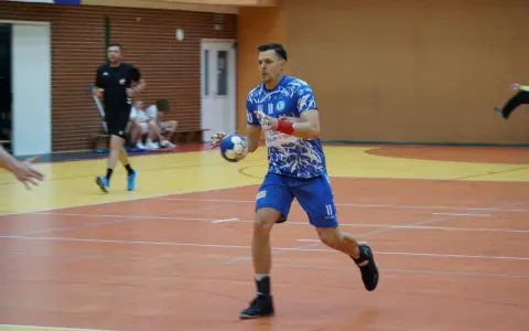 Kamil Krieger w akcji na boisku do piłki ręcznej, z piłką w dłoni, gotowy do rzutu.