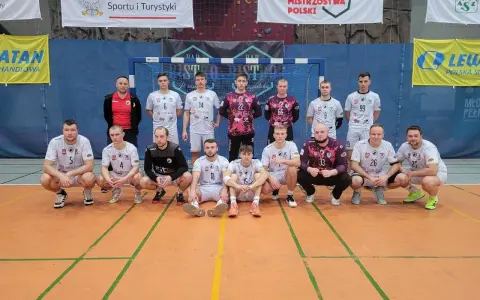 Drużyna piłkarzy ręcznych, w tym Wojciech Stec, pozuje do zdjęcia w hali sportowej.