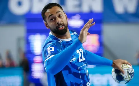 Gracz gog handball w niebieskiej koszulce z numerem 22, gotowy do rzutu.