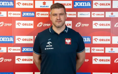 Mężczyzna w koszulce z orłem, podobny do Julena Aginagalde, stoi na tle ścianki z logotypami sponsorów, m.in. ORLEN.