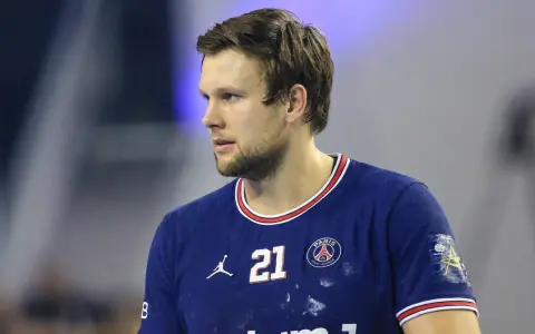 Piłkarz ręczny PSG z numerem 21 na koszulce, skupiony na grze.