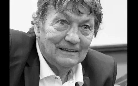Portret Ryszarda Jedlińskiego w garniturze i białej koszuli. Jego twarz jest lekko uśmiechnięta, a oczy patrzą wprost na widza.