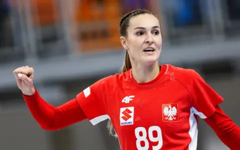 Kinga Achruk, zawodniczka z numerem 89 na czerwonej koszulce, unosi zaciśniętą pięść w geście triumfu.