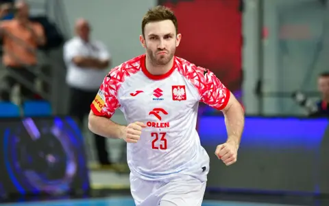 Piłkarz ręczny w koszulce z numerem 23 i godłem Polski biegnie na boisku. Sprawdź terminarz Mistrzostw Europy w piłce ręcznej!