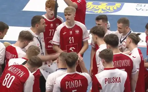 Drużyna PGNiG piłka ręczna w czerwonych strojach słucha trenera.