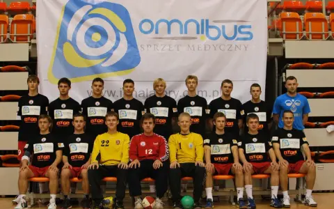 Drużyna piłkarzy ręcznych z Piotrem Burczyńskim na czele pozuje do zdjęcia.