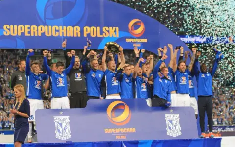 Drużyna w niebieskich strojach świętuje zdobycie Superpucharu Polski, unosząc trofeum i ciesząc się z wygranej wśród konfetti.
