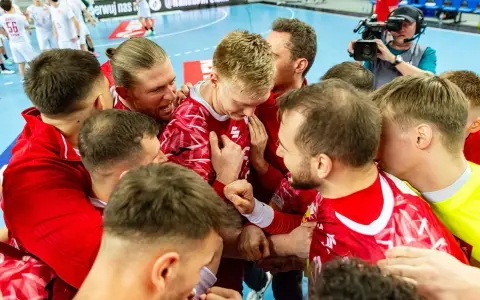 Piłkarze ręczni w czerwonych strojach świętują zwycięstwo. Emocje po meczu, a gdzieś w tle czeka mistrzostwa świata w piłce ręcznej terminarz.