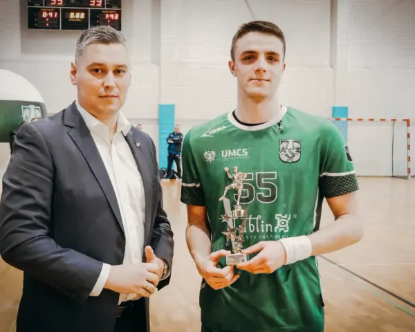 Andrzej Widomski z pucharem w ręku, obok młody sportowiec w zielonej koszulce.
