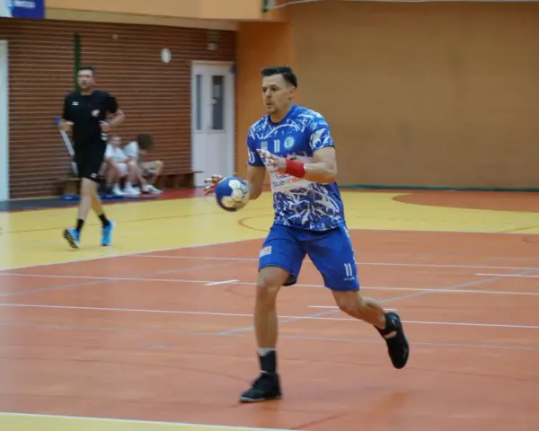 Kamil Krieger w akcji na boisku do piłki ręcznej, z piłką w dłoni, gotowy do rzutu.