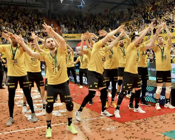 Drużyna MKS Lublin świętuje zwycięstwo na boisku, otoczona konfetti i wiwatującymi kibicami.