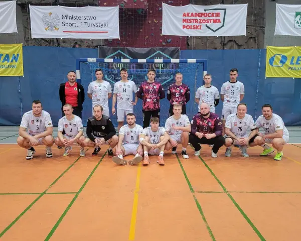 Drużyna piłkarzy ręcznych, w tym Wojciech Stec, pozuje do zdjęcia w hali sportowej.