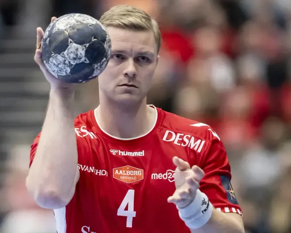Aron Palmarsson, zawodnik z numerem 4 na czerwonej koszulce, trzyma piłkę do piłki ręcznej, gotowy do rzutu.