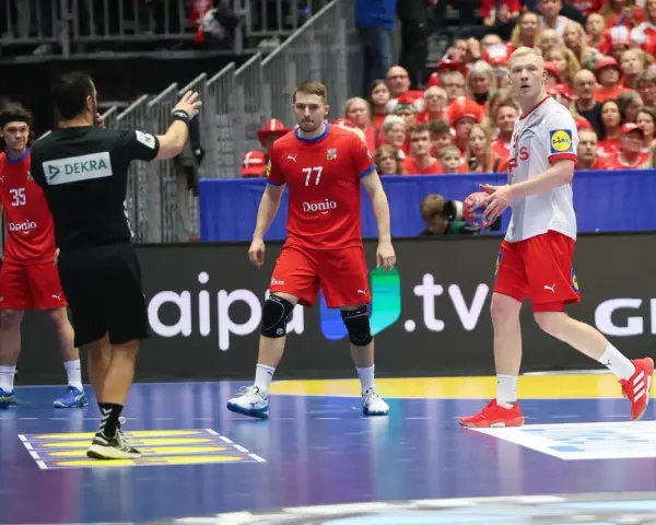 Daniel Reznicky w czerwonej koszulce z numerem 77 na boisku do piłki ręcznej.